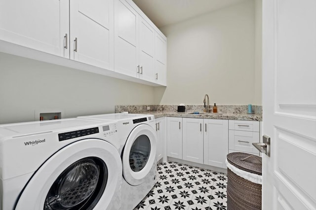 washroom featuring cabinets, sink, and washing machine and dryer