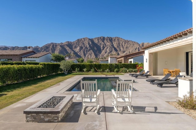 view of swimming pool featuring an outdoor fire pit, a patio area, and a mountain view