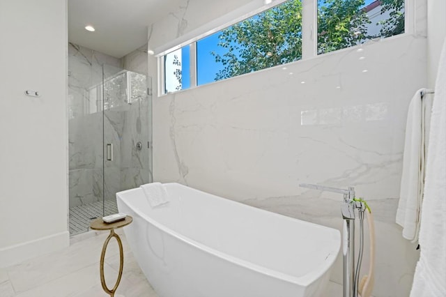 bathroom featuring shower with separate bathtub