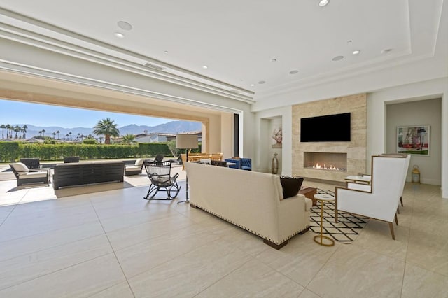 living room featuring a fireplace, light tile patterned flooring, and a mountain view