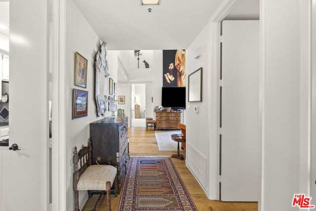 hallway with light hardwood / wood-style floors