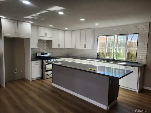 kitchen with dishwasher, white cabinets, stainless steel gas range, and a center island