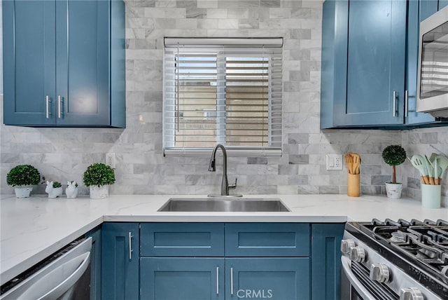 kitchen featuring backsplash, appliances with stainless steel finishes, sink, and blue cabinetry