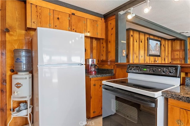 kitchen with electric stove, light tile patterned flooring, white refrigerator, and a textured ceiling