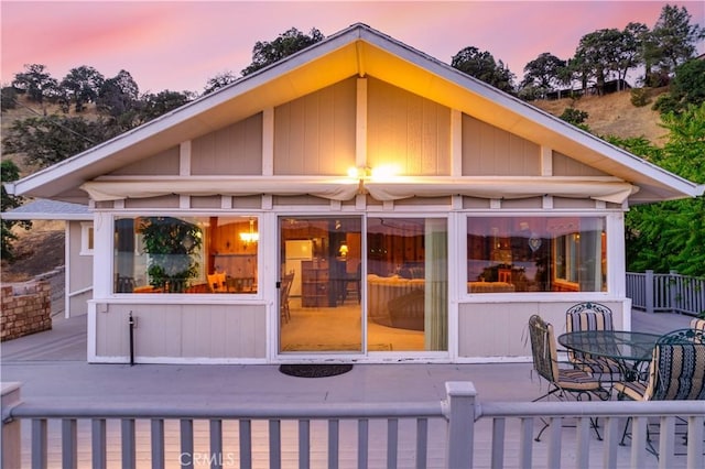 back house at dusk featuring a patio