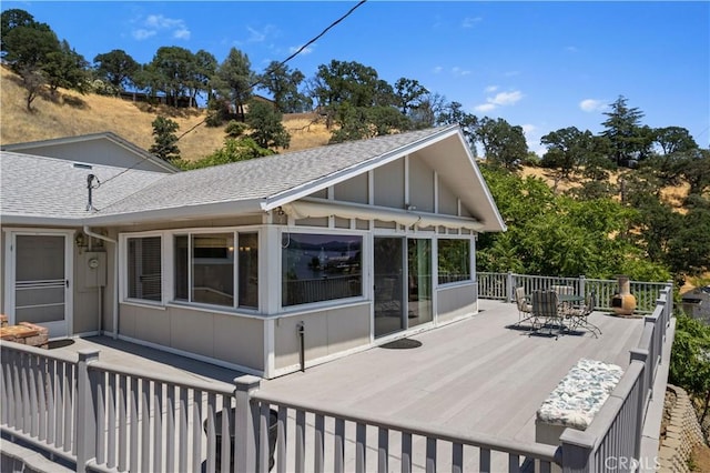 rear view of property with a deck and a sunroom