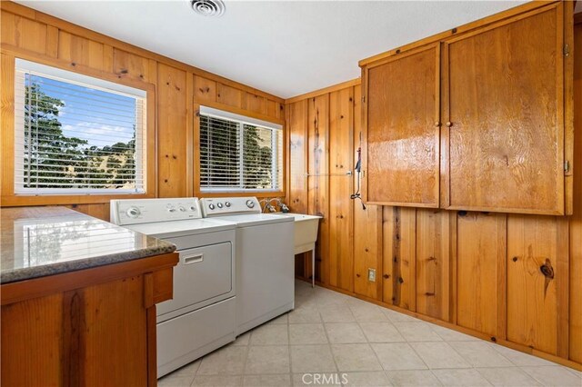 laundry area featuring washer and dryer and wooden walls