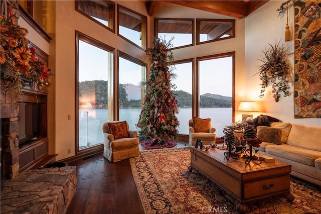 sunroom / solarium with a water view and a fireplace