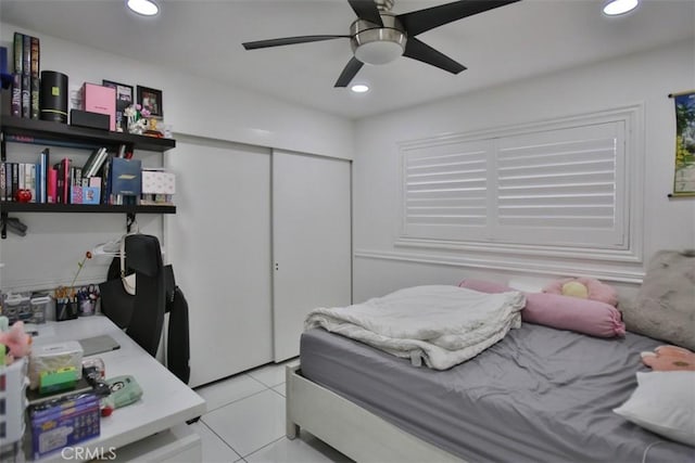 tiled bedroom with ceiling fan and a closet