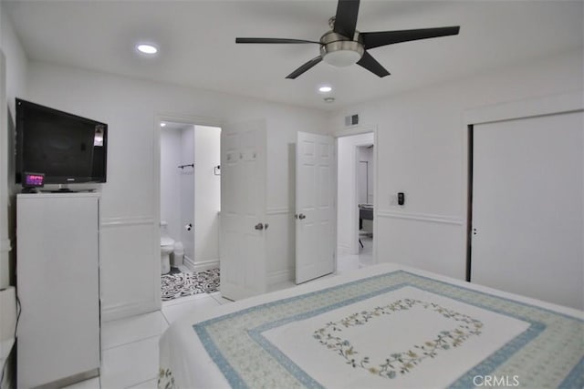 bedroom featuring ceiling fan, light tile patterned floors, and connected bathroom