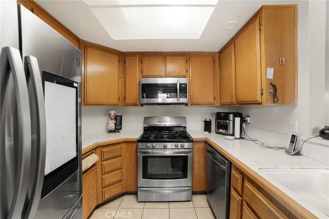 kitchen with sink, stainless steel appliances, and light tile patterned flooring