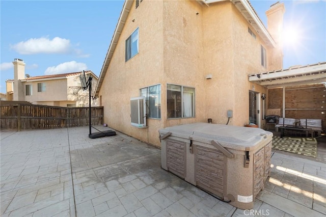 back of house with a patio area and a hot tub