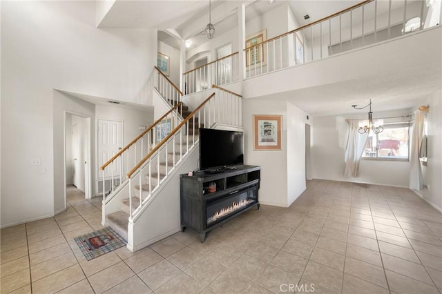 living room with an inviting chandelier, light tile patterned floors, and a high ceiling