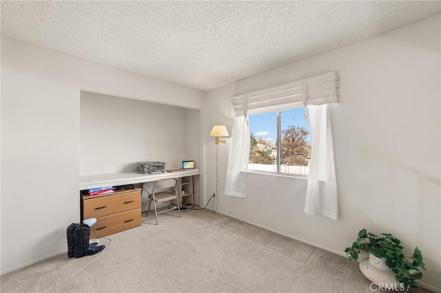 home office with a textured ceiling and light carpet