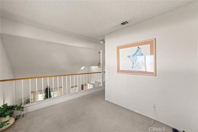 corridor with carpet floors and a textured ceiling