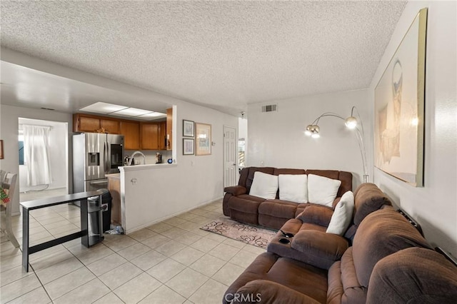 living room with a textured ceiling and light tile patterned floors