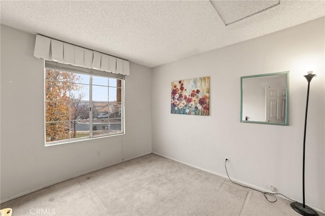 spare room with a textured ceiling and light colored carpet