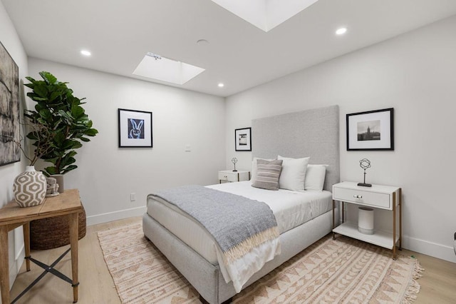 bedroom featuring a skylight and light wood-type flooring