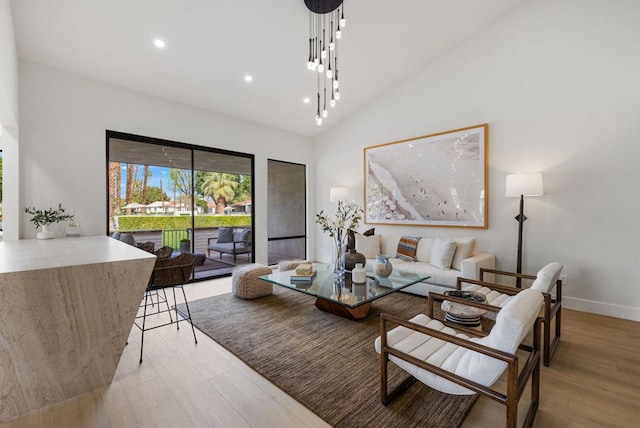 living room with high vaulted ceiling and light hardwood / wood-style flooring