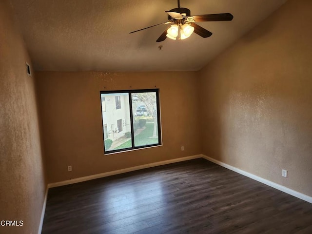 unfurnished room featuring ceiling fan, dark wood-type flooring, and lofted ceiling