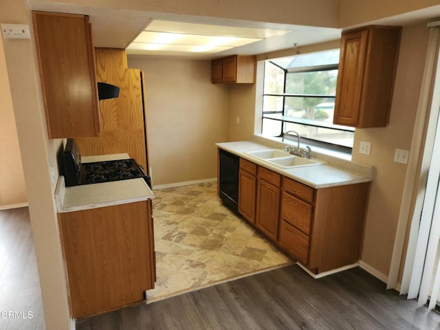 kitchen featuring extractor fan, sink, black dishwasher, light wood-type flooring, and gas range oven