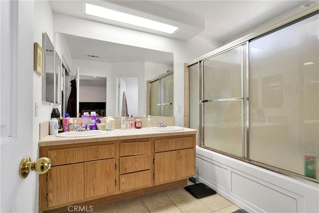 bathroom featuring enclosed tub / shower combo, tile patterned flooring, and vanity