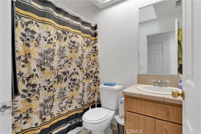 bathroom with toilet, vanity, and walk in shower