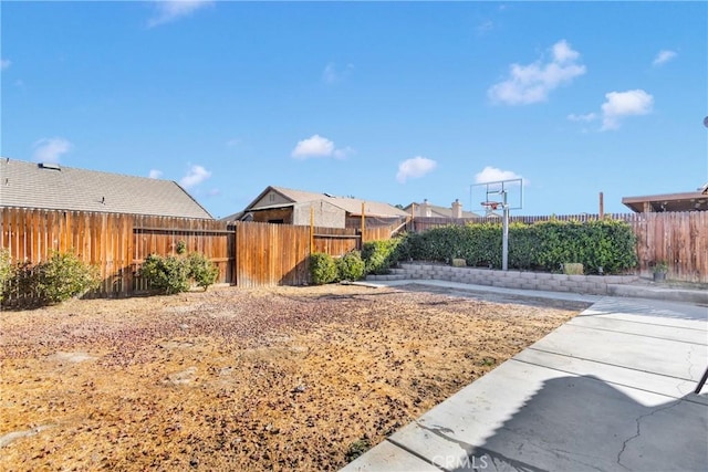 view of yard featuring basketball hoop