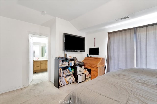 carpeted bedroom featuring ensuite bathroom and lofted ceiling