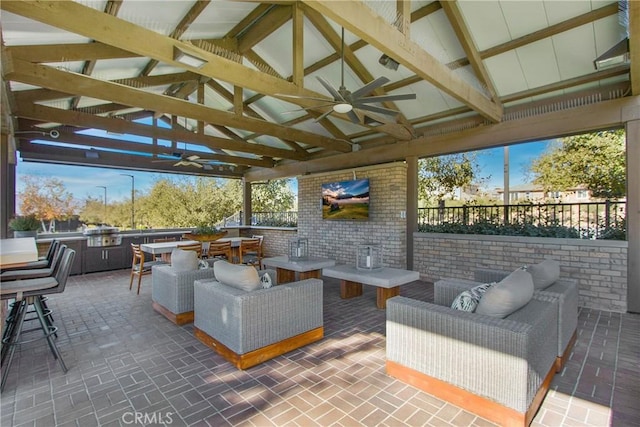 view of patio featuring ceiling fan, an outdoor kitchen, a gazebo, exterior bar, and an outdoor living space