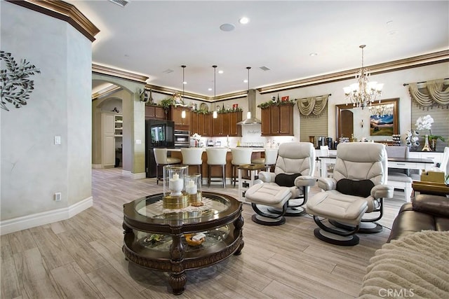 living room with ornamental molding and an inviting chandelier