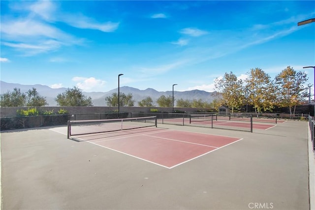 view of sport court featuring a mountain view and basketball hoop