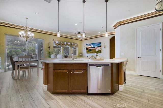 kitchen with an island with sink, dishwasher, hanging light fixtures, ornamental molding, and sink