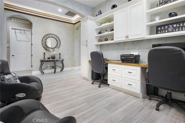 home office featuring built in desk and light hardwood / wood-style flooring