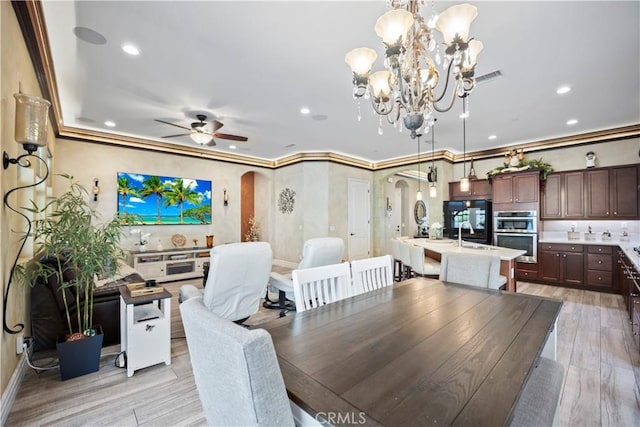 24368 Overlook Dr, Corona, CA 92883 - dining area featuring light wood finished floors, crown molding, arched walkways, and recessed lighting