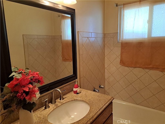 bathroom with a tub and vanity