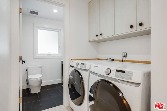 laundry room with dark tile patterned flooring and washing machine and dryer