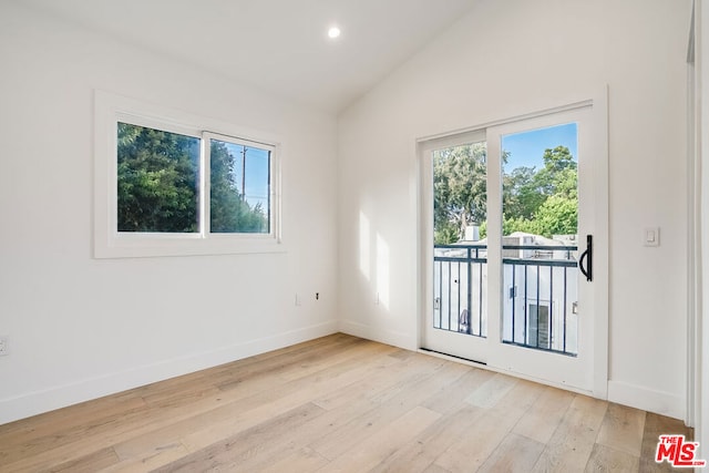 empty room with vaulted ceiling and light wood-type flooring