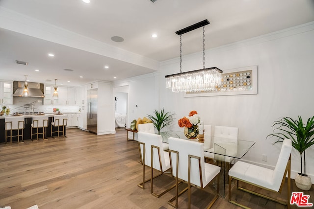 dining room with light hardwood / wood-style flooring and ornamental molding