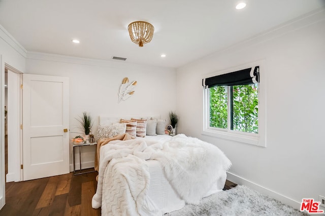 bedroom with crown molding and dark hardwood / wood-style floors