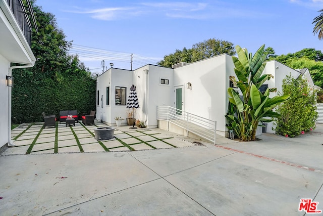 back of property with an outdoor hangout area and a patio