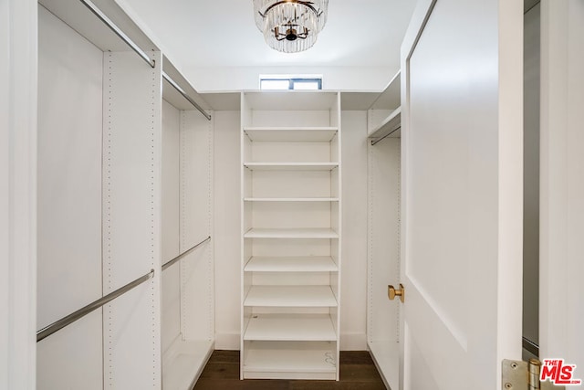 spacious closet with a chandelier