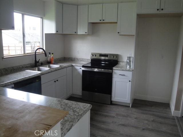 kitchen with dark hardwood / wood-style floors, dishwasher, sink, white cabinetry, and stainless steel range with electric stovetop