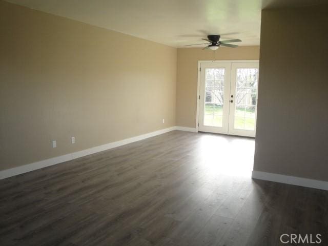 spare room with ceiling fan, french doors, and dark hardwood / wood-style flooring