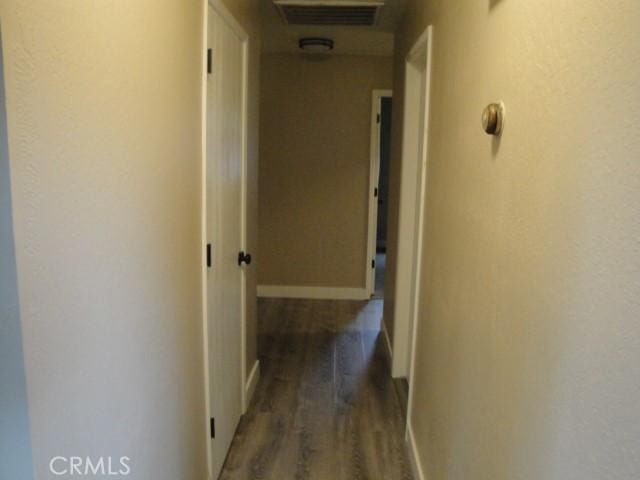 corridor with dark hardwood / wood-style flooring