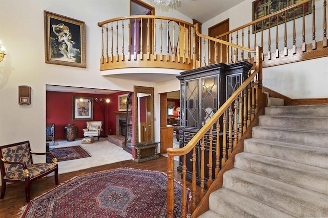 stairs featuring a towering ceiling and hardwood / wood-style floors