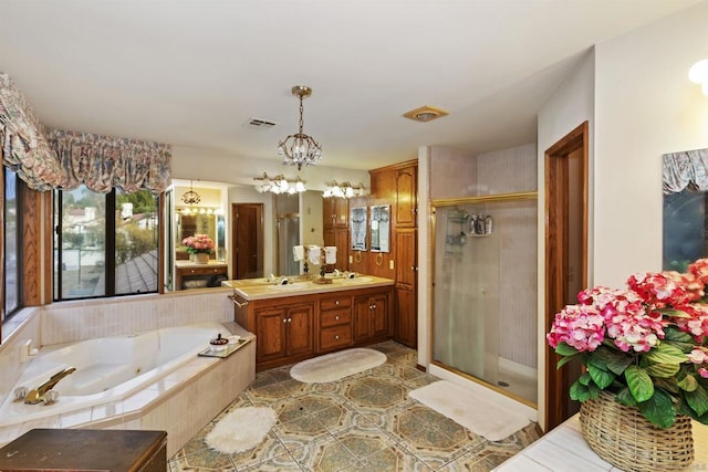 bathroom featuring a notable chandelier, vanity, and shower with separate bathtub