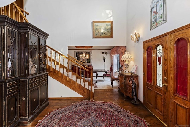 foyer featuring a towering ceiling and dark hardwood / wood-style floors