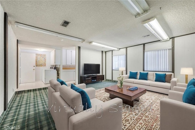 living room with independent washer and dryer and a textured ceiling