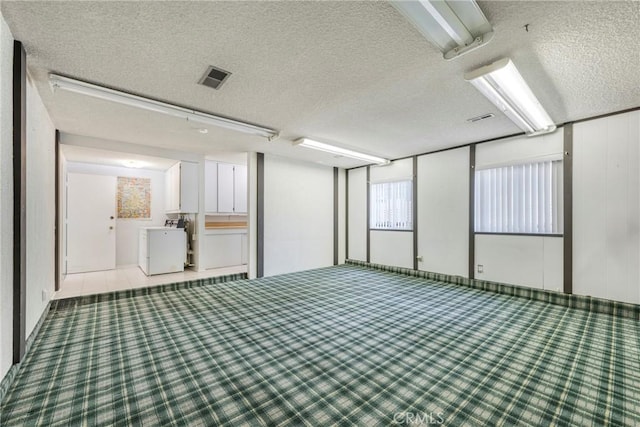 empty room featuring a textured ceiling and washer / clothes dryer